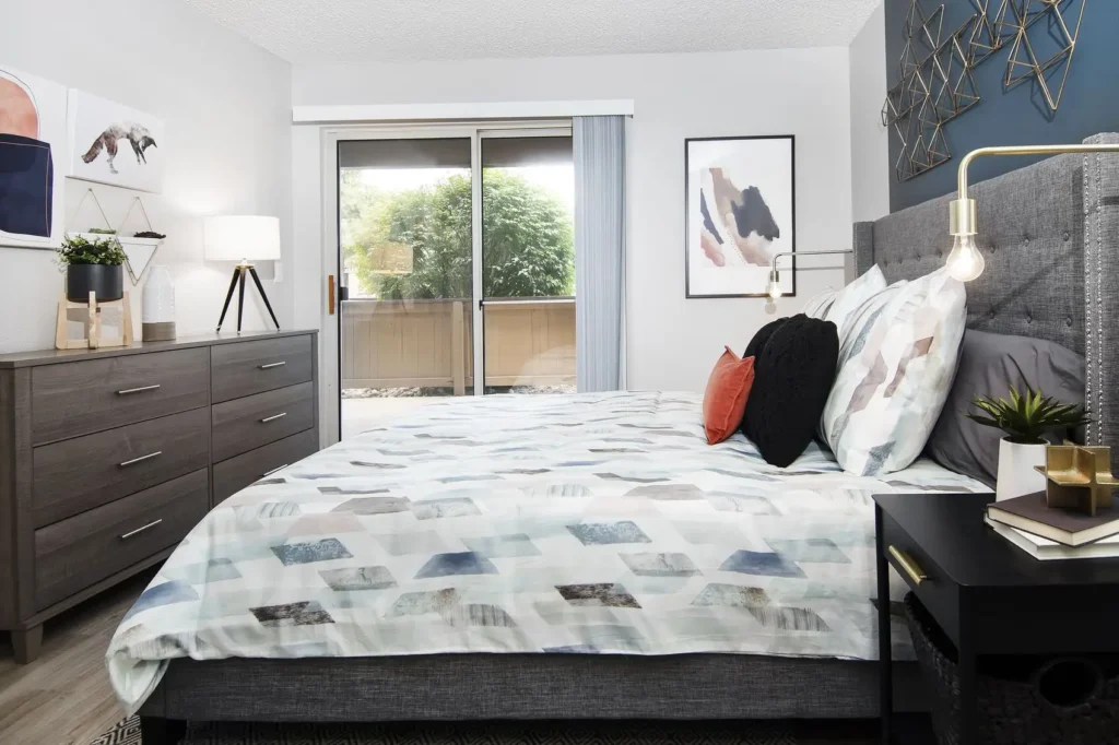 Staged bedroom with blue accent wall and glass patio doors