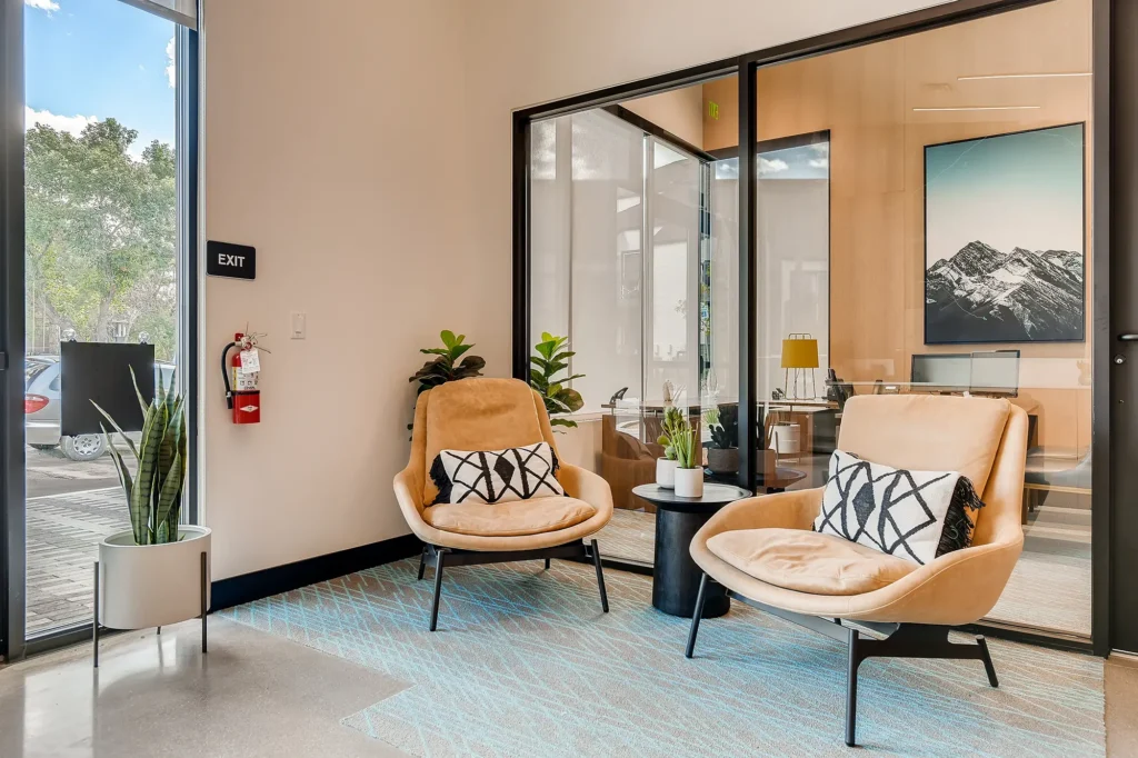Leasing office lobby with arm chairs and private offices