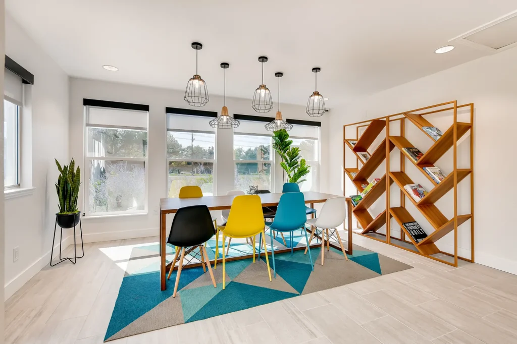 Clubhouse business center with conference table and chairs, large windows