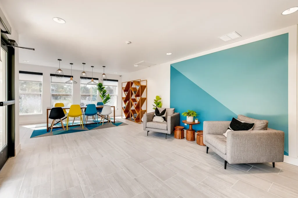 Clubhouse business center with table and chairs, shelf with books