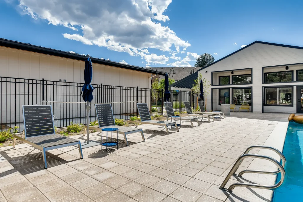 Pool with deck seating and umbrellas